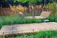 Extensive planting along Timber walkway and timber resting area. Grasses along metal fence. Description: The Sky is The Limit. Design: Sam Ovens 