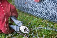 Fencing off a Rabbit hole - Cutting off length of chicken wire to cover rabbit hole