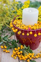 Candle holder decorated with Pyracantha berries