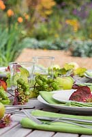 Table place setting decorations using hops, apples and acer rufinerve foliage