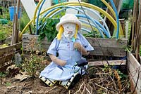 Little Miss Muffet girl scarecrow sitting in compost, Paddock Allotments 