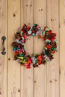 Colourful Christmas wreath made with ribbon. A wire wreath frame is wrapped 48 lengths of ribbon, each 45cm long, and in 8 different designs that are repeated, and tied in bows.