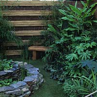 Inexpensive fence created from rolls of willow screen with horizontal lines of six canes at regular intervals to add distinctive look.
