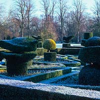 Formal, early 20th century knot garden. Yew topiary - peacocks, chess pieces and abstract shapes. Low box hedges mark parterre pattern.
