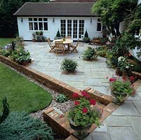 After makeover - It takes three months to transform the old terrace, quadrupling its size and planting in beds beside the house to soften its angles.