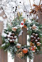 Christmas wreath attached to a fence.