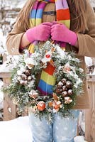 Girl with a home made Christmas wreath.