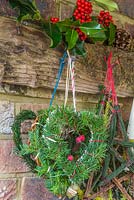 Mixed evergreen hearts hanging on a rustic tool rack. Taxus baccata and Pinus