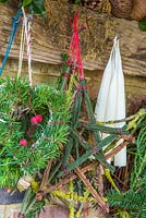 Mixed evergreen hearts hanging on a rustic tool rack. Taxus baccata and Pinus