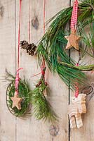 A variety of evergreen wreaths with wooden stars, pine cones and a reindeer