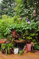 Wooden deck with lilac tree decorated with a vine and birdhouses in urban back garden, Quebec, Canada