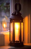 Vintage candle lantern on window ledge in winter