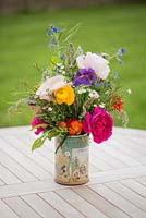 A cut flower arrangement on a garden table.