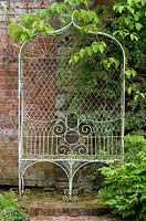 Ornate wrought iron garden bench . Abbey Dore Gardens, Herefordshire.