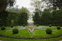 Parterre with star shaped borders and trimmed shrubs bordered by green lattice frames with path in formal garden at the Linderhof palace in late summer, Bavaria, Germany