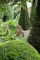 The Well Garden with tall yew spires and clipped box. Wollerton Old Hall, nr Market Drayton, Shropshire, UK
