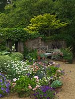 Front garden with pots of geranium, lobelia, Surfinia petunias, Scaevola aemula, box, busy lizzies 'Fiesta Appleblossom', 'Fiesta Pink Ruffle', marguerite, lobelia, hosta, phormium, echeveria.
