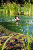Man swimming in a swimming pond. September.