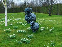 A spring scene is created with tufts of naturalised snowdrops surrounding metal sheep sculptures.