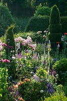 Mixed herbaceous border in midsummer with topiary
