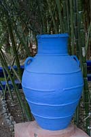 Amphora terracotta container painted blue in front of bamboo. Jardin Majorelle, Yves Saint Laurent garden