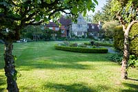 Spacious lawns stretch away from the Grade II listed Jacobean manor house. King John's Nursery, Etchingham, East Sussex, UK