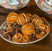 Making potpourri. Home made spicy citrus Christmas potpourri made from oranges, cinnamon and pine cones.