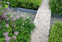 Chesterton Humbers 'A Game of Contrast', Malvern Spring Gardening Show 2014, offers a study of the relationship between man and the natural world, with pebble and concrete path crossing rill with pebbles - Designer: Lorenzo Soprani Volpini - LSV Gardens and Associates