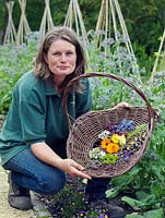 Jo Campbell with a basket of freshly picked edible flowers to include borage, marigold, courgette, thyme, lavender, borage, bean and viola.