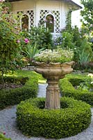 Decorative urn and pavillion in formal garden