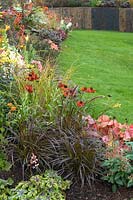 Wide, colour themed borders beside manicured lawn