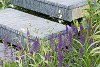 Steps made from hand-cut slate stacked together, flanked by foxgloves and Euphorbia pasteurii. The Brewin Dolphin Garden. RHS Chelsea Flower Show, 2015