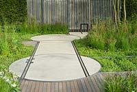 Rails embedded in pathway and rotating discs to carry moveable 'shack'. The Cloudy Bay and Bord na Mona garden, Chelsea Flower Show 2015

