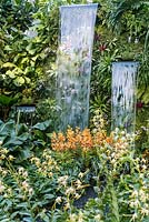 Waterfalls and orchid varieties including Dendrobium 'Asian Youth Games Singapore 09' and Aranda 'Singa Gold' - The Hidden Beauty of Kranji by Esmond Landscape and Uniseal. RHS Chelsea Flower Show, 2015