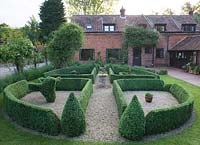 View of boxand gravel parterre looking toward house. Buxus sempervirens.