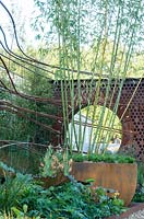 The Dark Matter Garden for the National Schools' Observatory - a hard core design with upcycled steel is planted with bamboo, Verbascum, and Ligularia. RHS Chelsea Flower Show, 2015