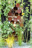The Great Chelsea Garden Challenge Garden. Detail of rusted tin cans for insect homes. RHS Chelsea Flower Show, 2015