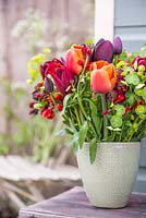 Floral display of Euphorbia, Wallflowers, Tulip 'Brown Sugar', Tulip 'National Velvet' and Tulip 'Queen of Night'