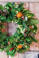 Christmas wreath with dried fruit and cinnamon bundles mounted on a door
