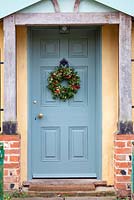 Christmas wreath hanging on a grey door