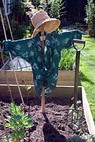 Scarecrow in vegetable bed, early spring