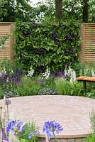 The Wellbeing of Women Garden. A living wall of fern, heuchera and grasses, behind patio.  Designers: Claire Moreno, Wendy von Buren and Amy Robertson.