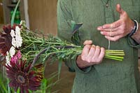 Creating flower bunches for a farmers market. Creating individual bundles and securing together with a rubber band