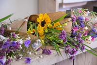 Creating flower bunches for a farmers market. A variety of completed flower bundles on work surface