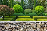 Garden in Luberon, France, Designed by Michel Semini: Stone wall, clipped topiary and cypress trees in a formal garden - Wasserman garden