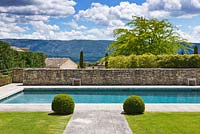 Lawn and path to swimming pool, Luberon hills behind. 
