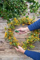 Use some green crafting wire to secure the Pyracantha branches to the wreath