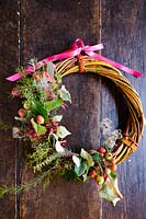 Handmade willow wreath using hedgerow fruits and foliage, decorated wth a pink ribbon - Common Farm Flowers, Somerset