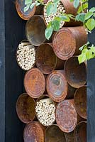 The Great Chelsea Garden Challenge Garden. Rusted alluminium cans used for insect hotels. Designer - Sean Murray. Sponsor - Royal Horticultural Society
