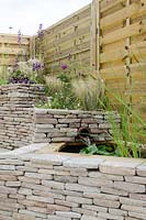 Dry stone wall with water feature, mixed planting of Stipa tenuissima, Verbena bonariensis and Erigeron karvinskianus - 'Traditional Modernism' - Ideal Young Gardener of the Year - Silver Medal at The Bath and West Garden Show 2012